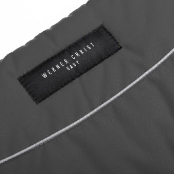 Nahaufnahme eines Labels mit der Aufschrift 'WERNER CHRIST BABY' auf einem grauen Handwärmer.