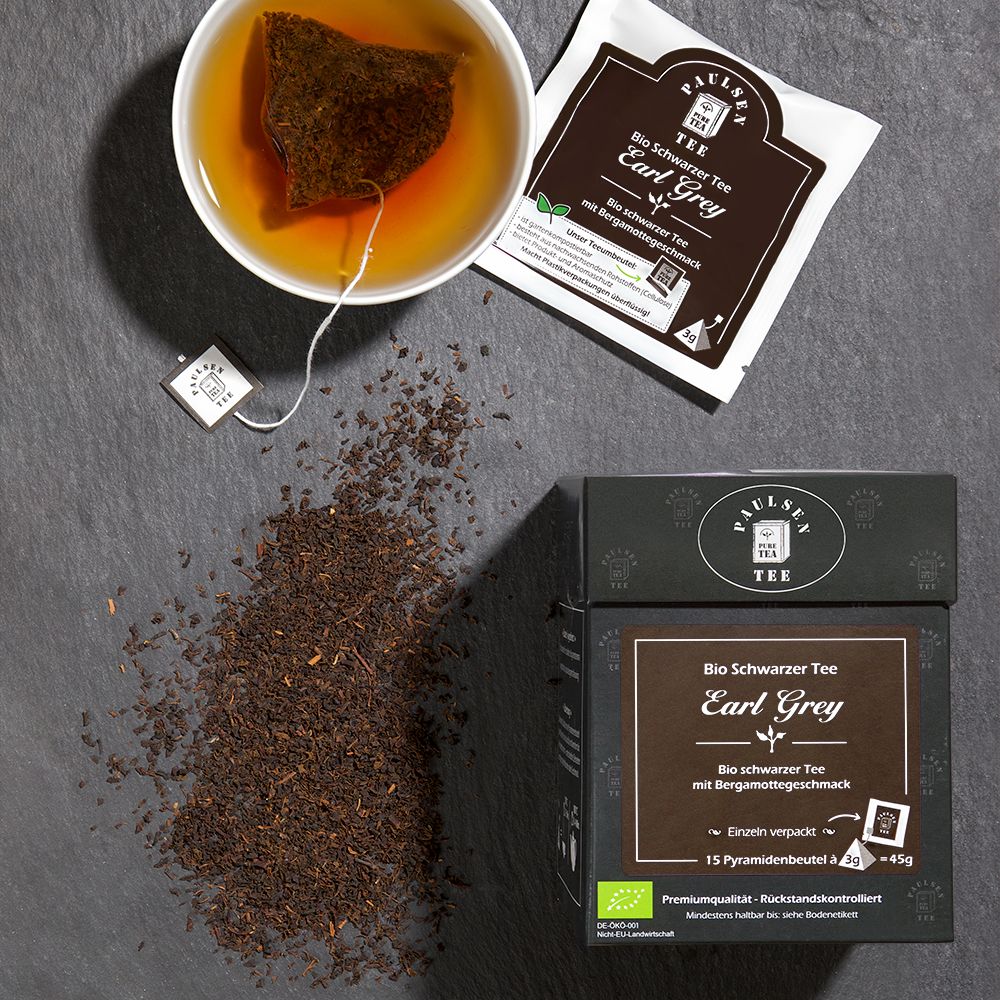 Schwarzer Tee Earl Grey, Pyramidenbeutel, Tasse Tee, lose Teeblätter. Schwarze Schachtel mit Logo.