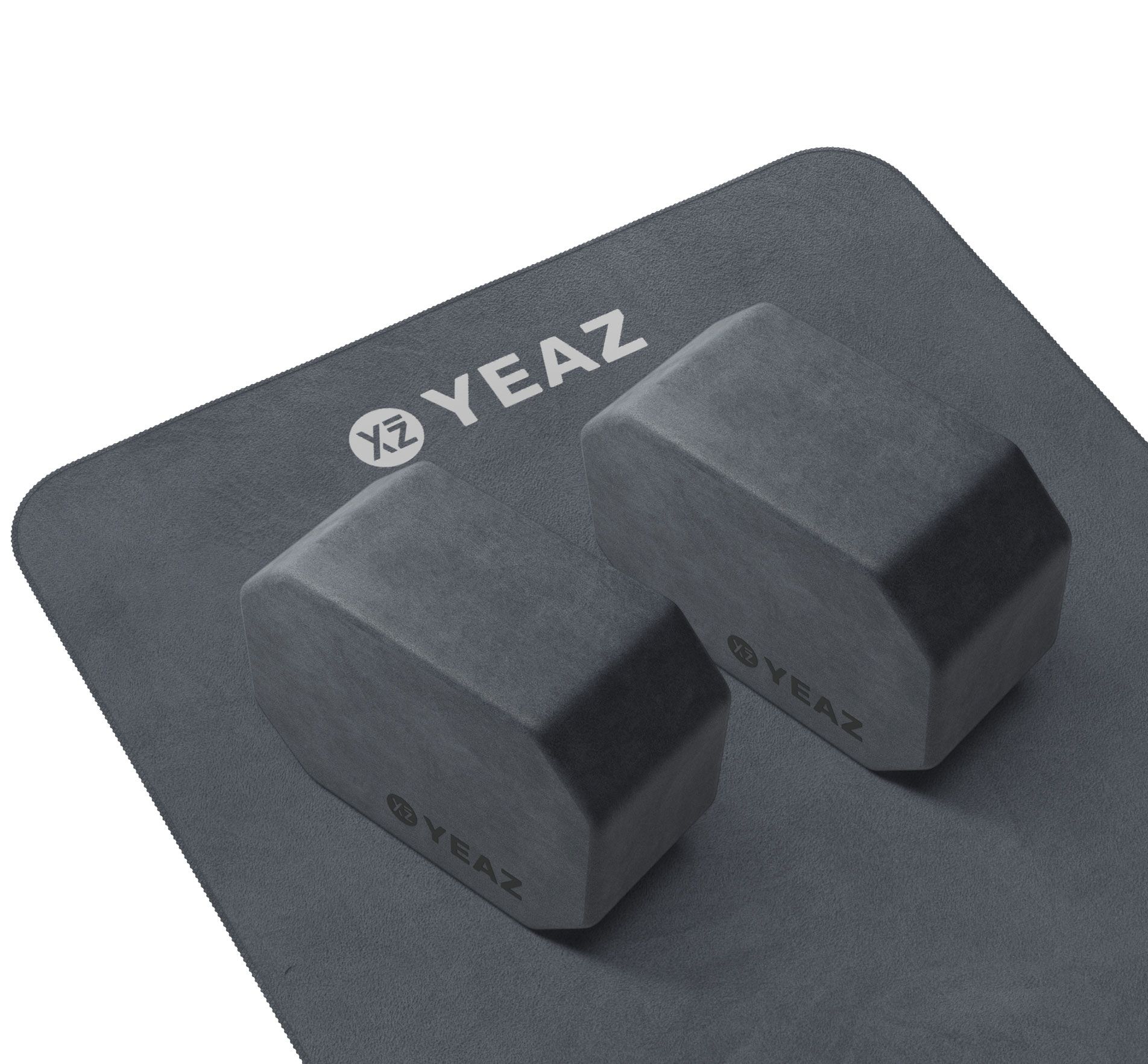 Graues Yoga-Set mit zwei Blöcken und Matte. Blöcke mit YEAZ-Logo. Matte mit abgerundeten Ecken.