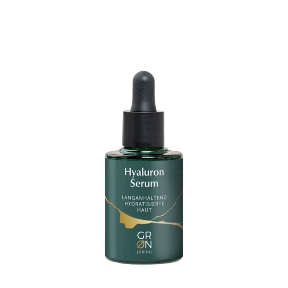 Grüne Glasflasche mit schwarzem Deckel und Pipette. Aufschrift: Hyaluron Serum. Goldene Linien auf der Flasche. Marke: GRÜN.