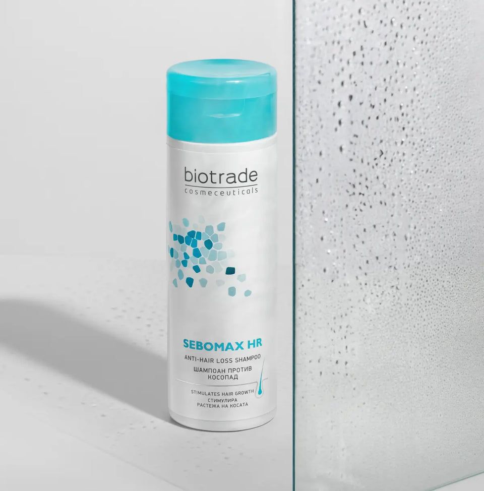 Biotrade Sebomax HR Shampoo, weiße Flasche mit blauem Deckel. Text: Sebomax HR, Anti-Haarausfall Shampoo. Blaue und türkise Punkte.