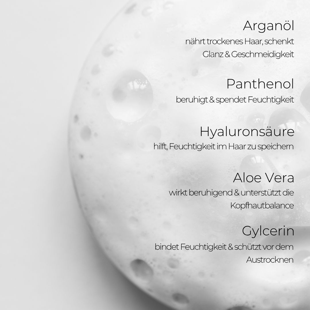 Nahaufnahme von Schaum. Text: Arganöl, Panthenol, Hyaluronsäure, Aloe Vera, Glycerin. Beschreibt Inhaltsstoffe und Wirkung.