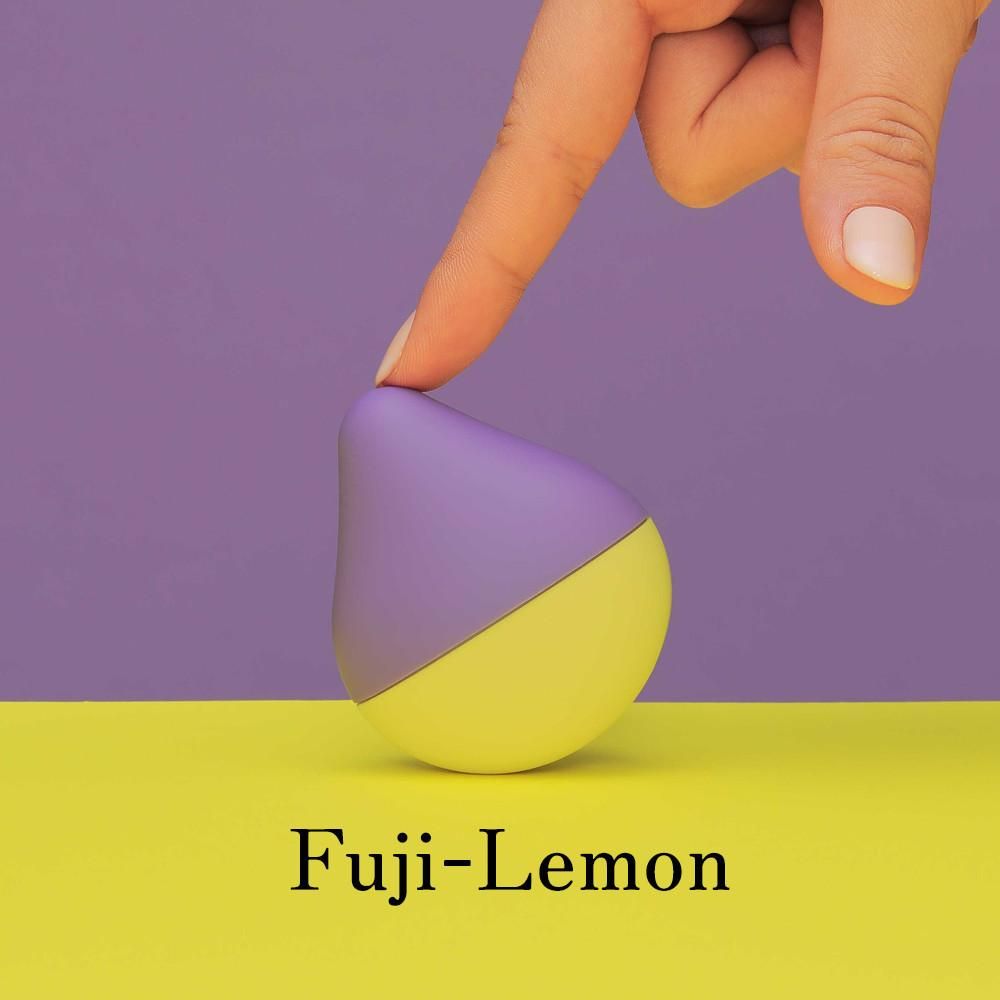 Produkt in Tropfenform, lila/gelb. Finger berührt das Produkt. Hintergrund: lila/gelb. Text: Fuji-Lemon.
