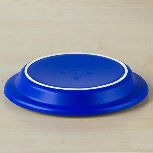 Unterseite eines blauen Tellers mit weißem Rand. Der Teller liegt auf einer Holzoberfläche.