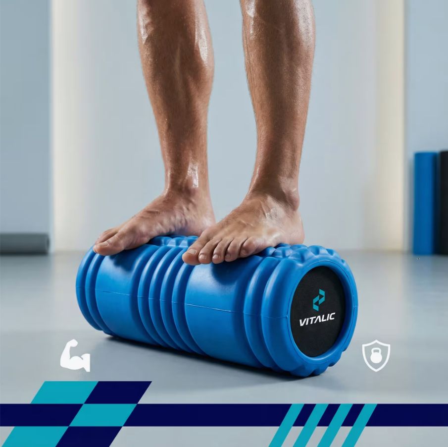 Mann steht auf blauem Faszienrolle. VITALIC Logo auf dem Rolle.