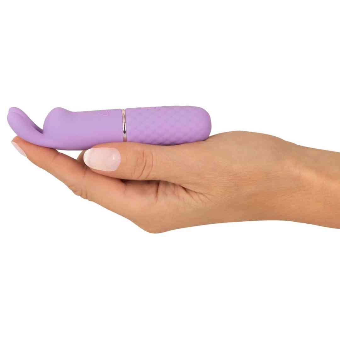 Lila Vibrator in Hand gehalten. Hasenohren-Design, geriffelte Basis, goldfarbener Ring.