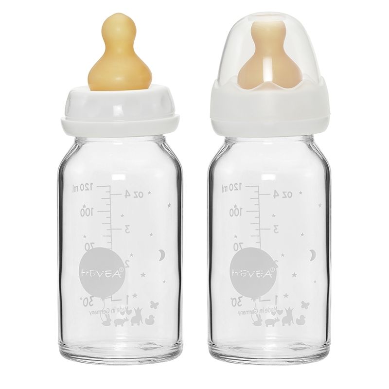 Zwei Babyflaschen aus Glas mit Messskala und Aufdruck. Eine Flasche mit Sauger, die andere mit Deckel. Marke: HEVEA.