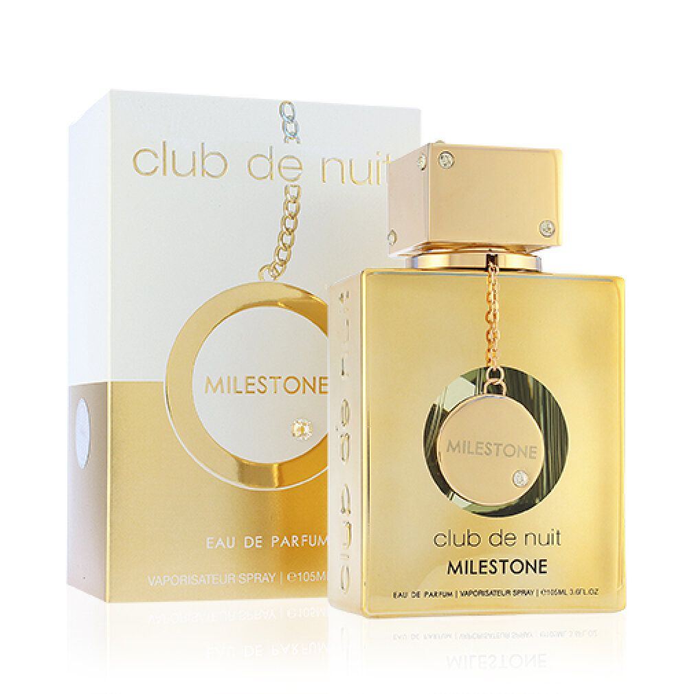 Goldfarbener Flakon mit weißer Verpackung. Aufschrift 'Club de Nuit Milestone'. Flakon mit Anhänger und Schmucksteinen.