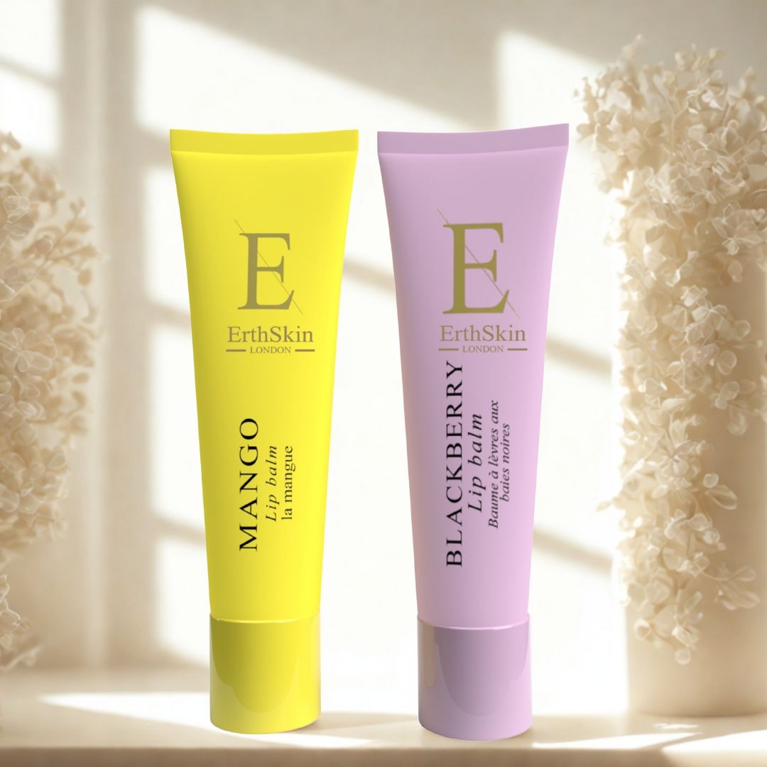 Zwei Lippenbalsam-Tuben: Gelb und Lila. Aufschrift: Mango, Blackberry. Marke: ErthSkin London. Hintergrund: verschwommene Blüten.