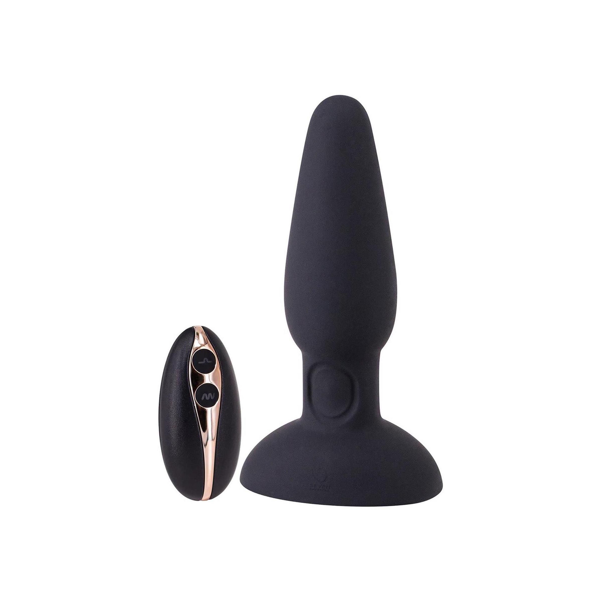 Schwarzer Silikon-Butt Plug und Fernbedienung. Goldfarbene Akzente. Konische Form, breite Basis.