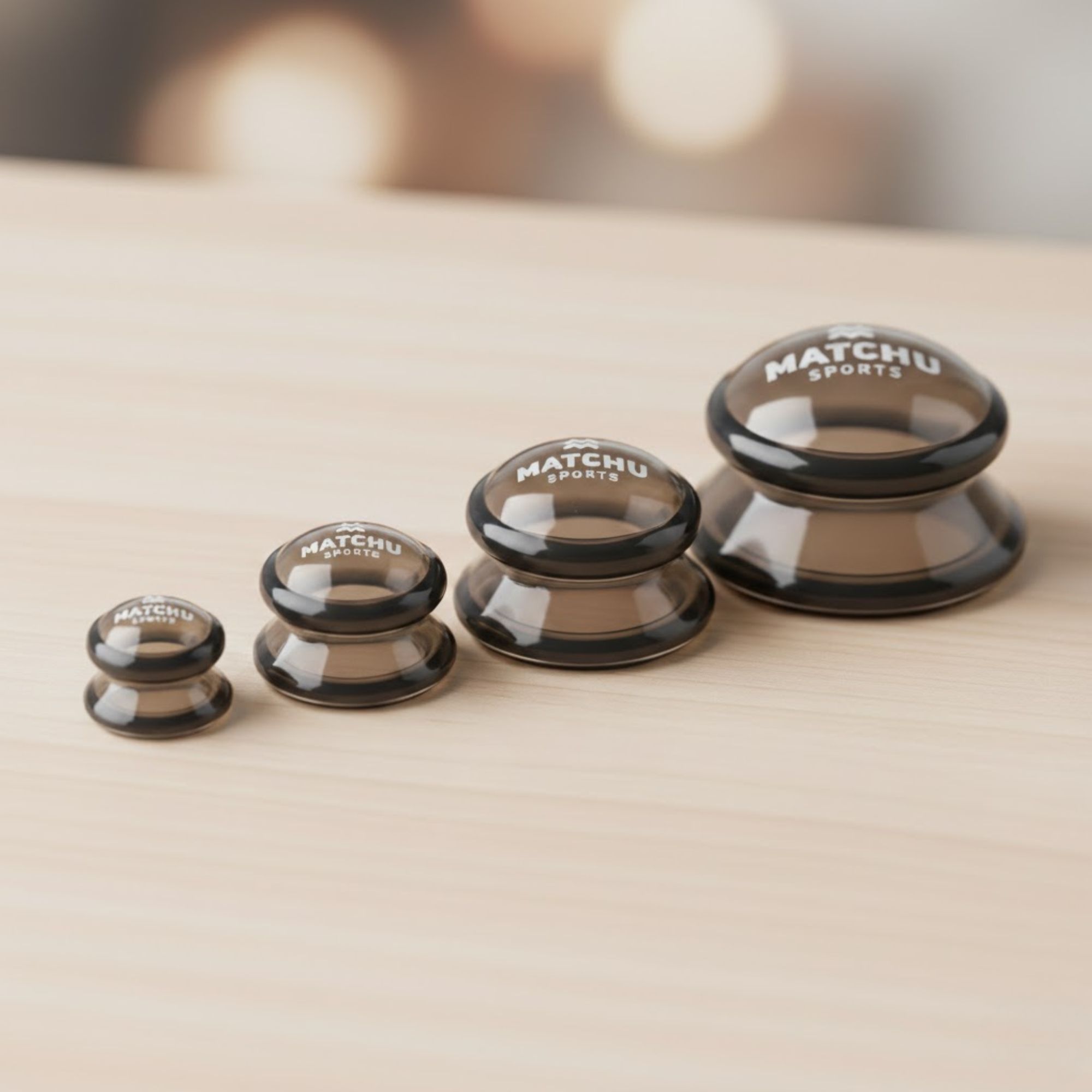 Vier Schröpfköpfe, transparent-braun, in verschiedenen Größen. Mit "MATCHU SPORTS" beschriftet.
