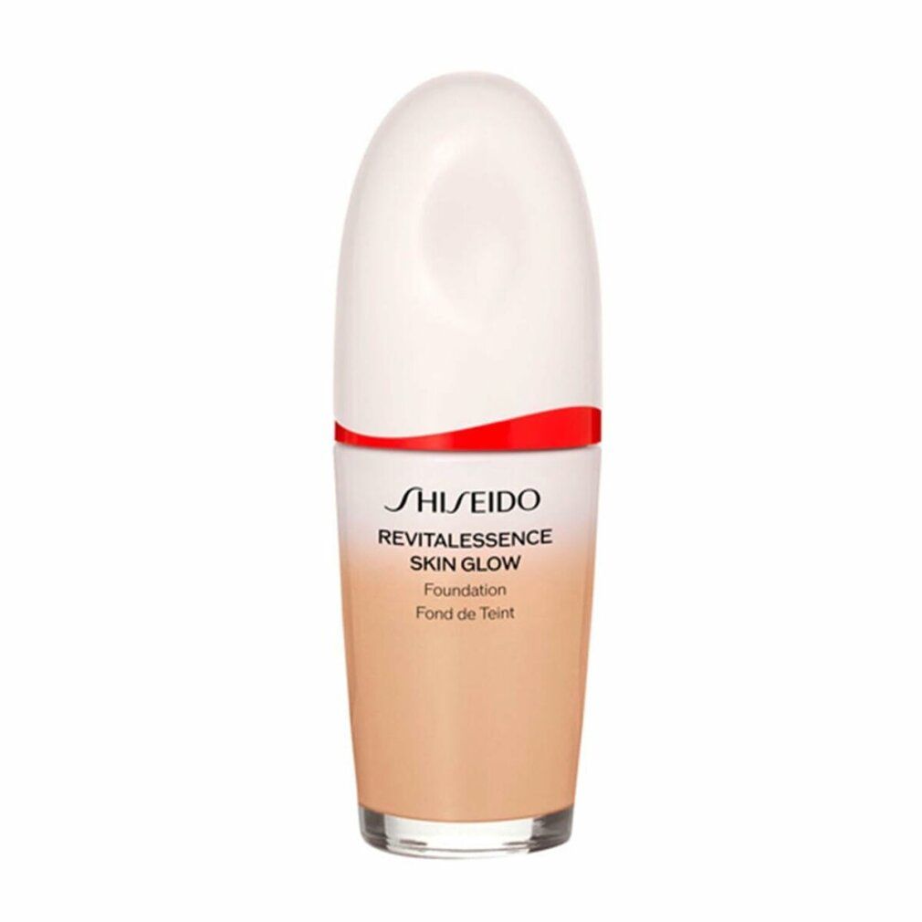 Kosmetikflasche mit weißem Deckel, rotem Band und Farbverlauf. Aufschrift: Shiseido Revitalessence Skin Glow Foundation.