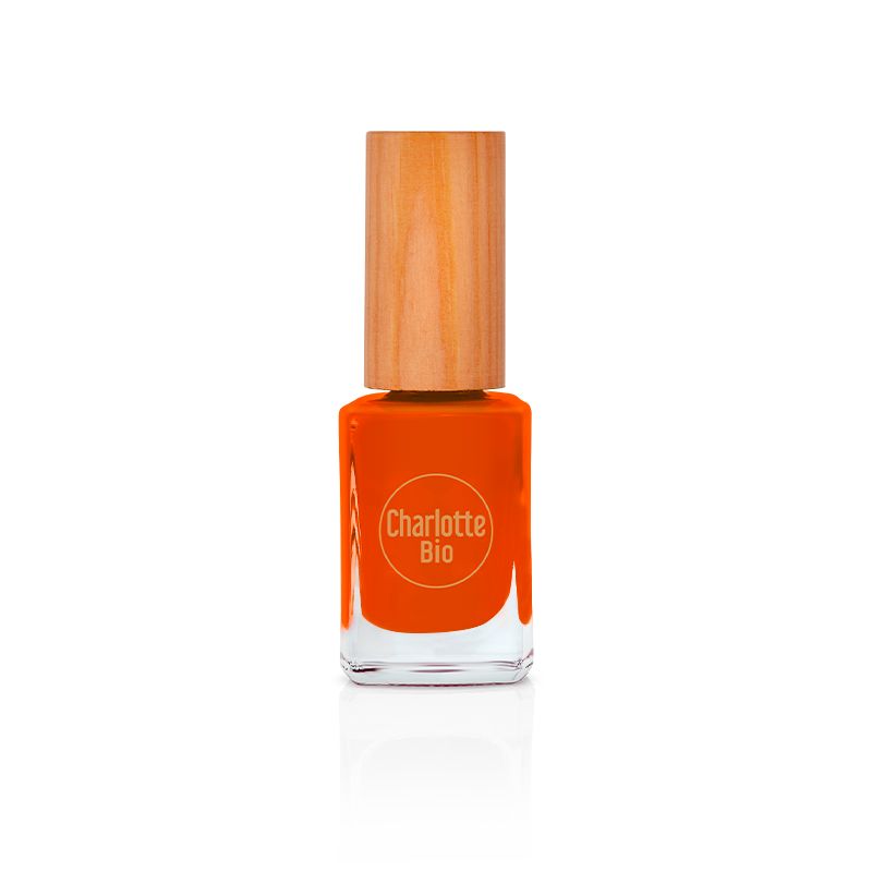 Nagellackflasche mit orangefarbenem Inhalt und Holzverschluss. Auf der Flasche ist das Logo Charlotte Bio zu sehen.