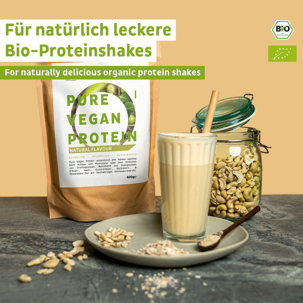 FAIRNATURAL Bio Vegan Protein Pulver in Beutel, Glas mit Cashews, Becher mit Shake und Schale mit Nüssen.