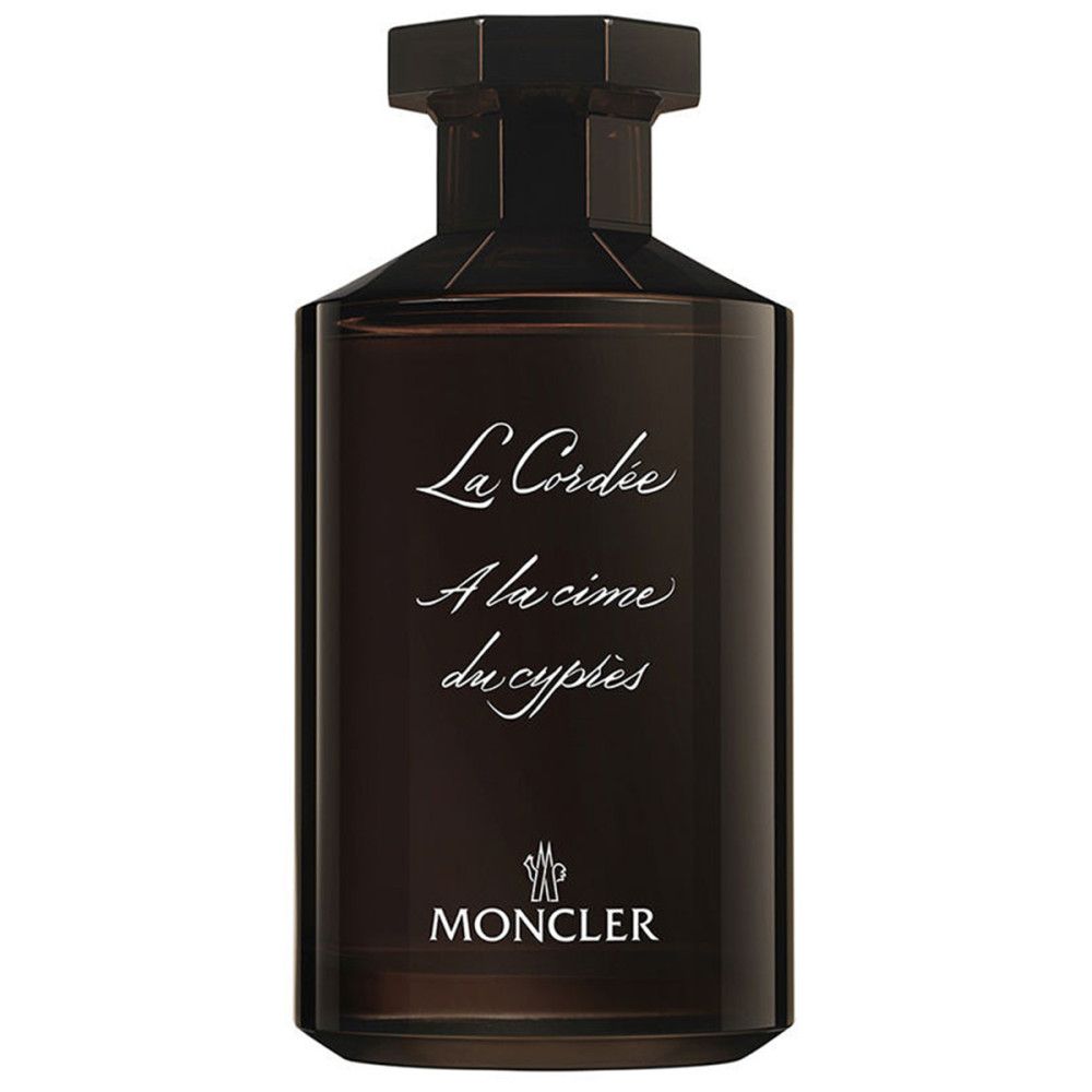 Dunkelbraune Glasflasche mit achteckigem Verschluss. Weiße Schrift: "La Cordée", "A la cime du cypres", "MONCLER".