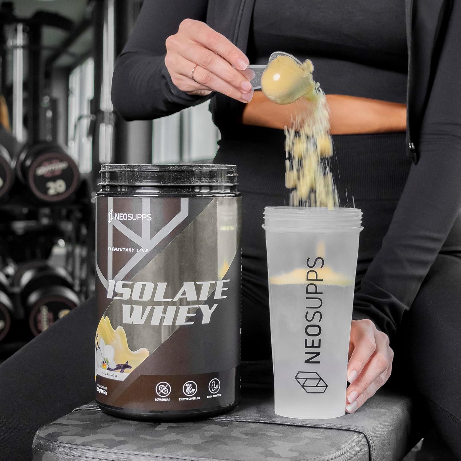 Person gießt Pulver aus Dose in Shaker. Aufschrift: Neosupps Isolate Whey, Elementary Line. Shaker.