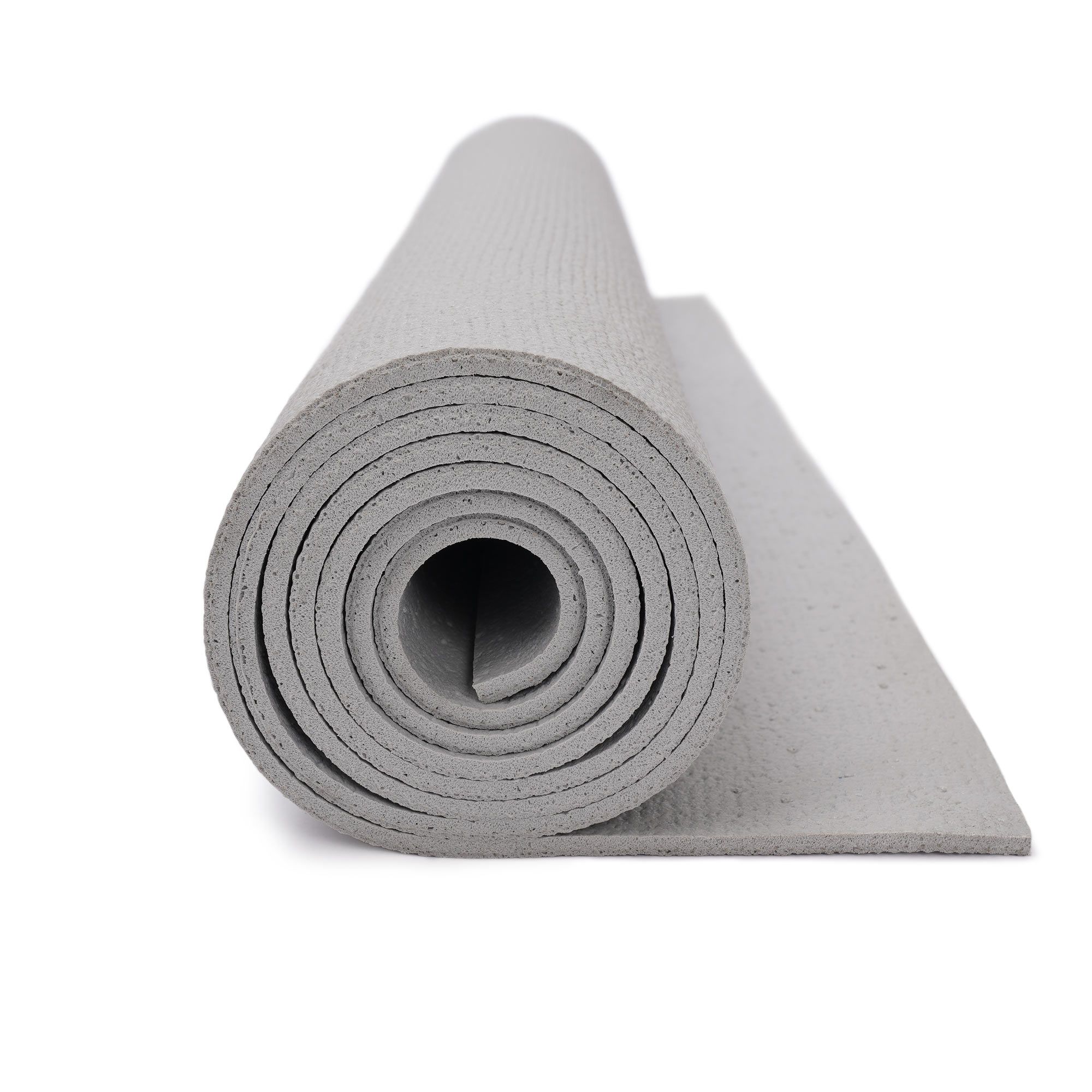 Nahaufnahme des aufgerollten Rands einer hellgrauen Yogamatte, die Dicke ist sichtbar.