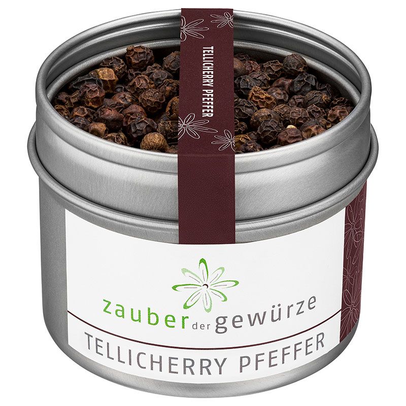 Metallbehälter mit Tellicherry Pfeffer. Etikett mit Produktnamen und Logo. Dunkelbraune Pfefferkörner.