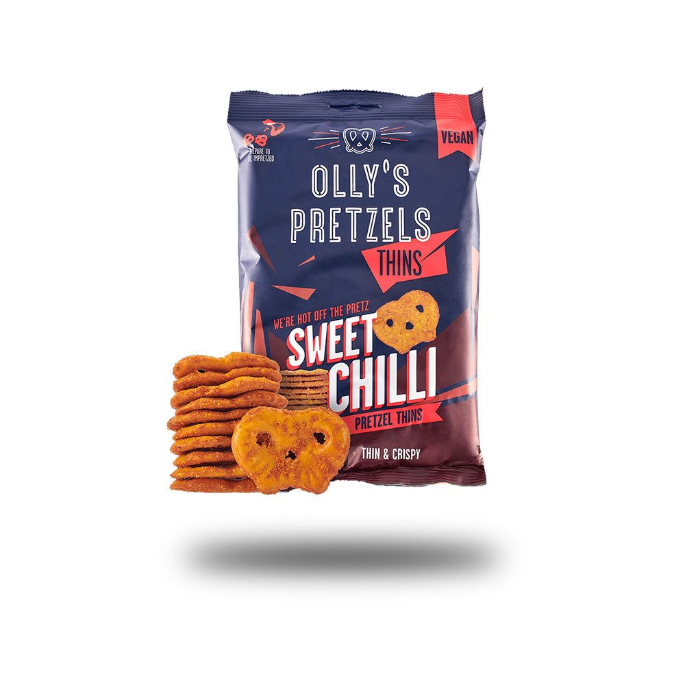 Packung Olly's Pretzel Thins, Sorte Sweet Chilli. Daneben Pretzel-Stapel und einzelne Brezeln. Vegan.