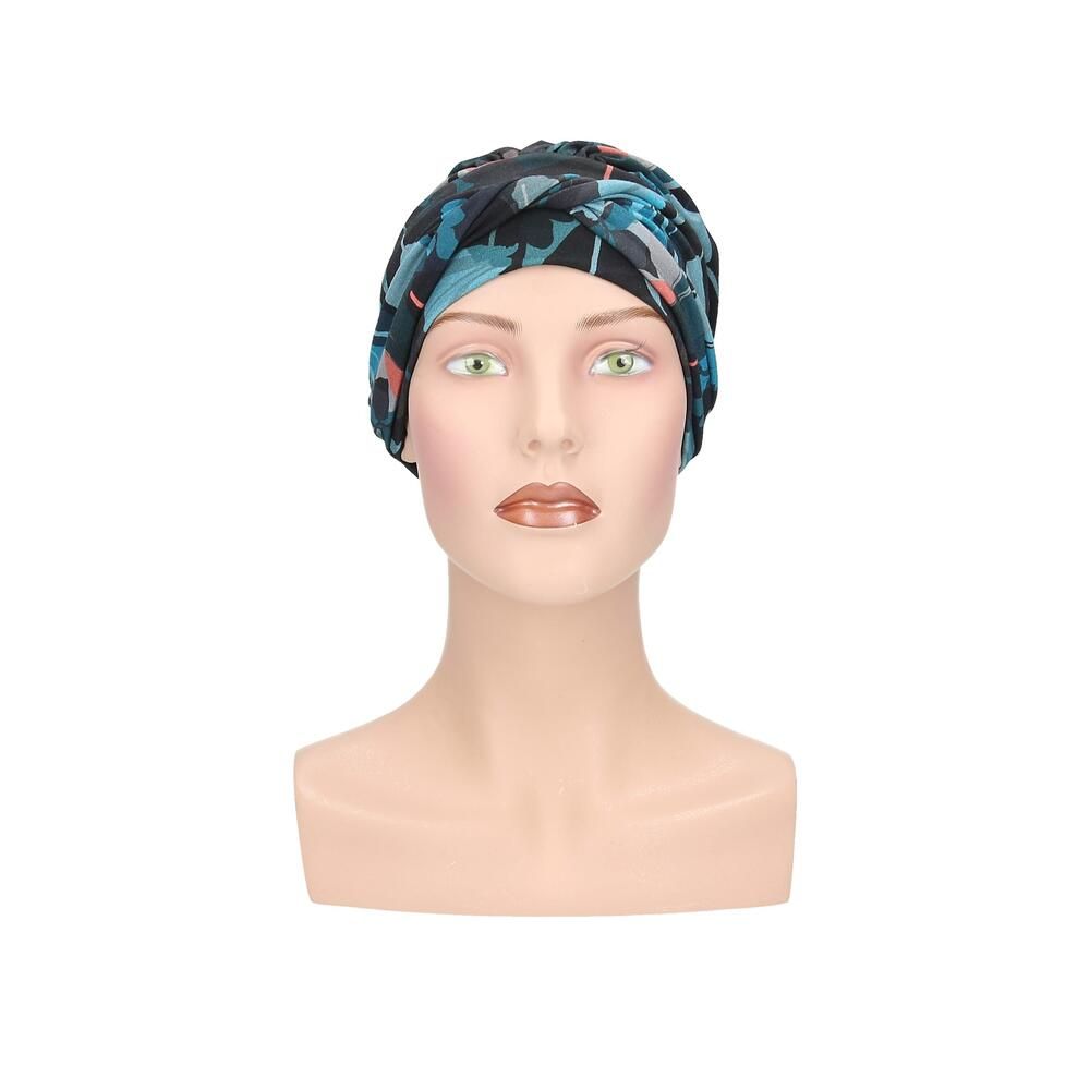 Turban Letti, floral bedruckt, auf einer Büste. Farben: Schwarz, Türkis, Rosa. Stoff mit Falten. Frontansicht.