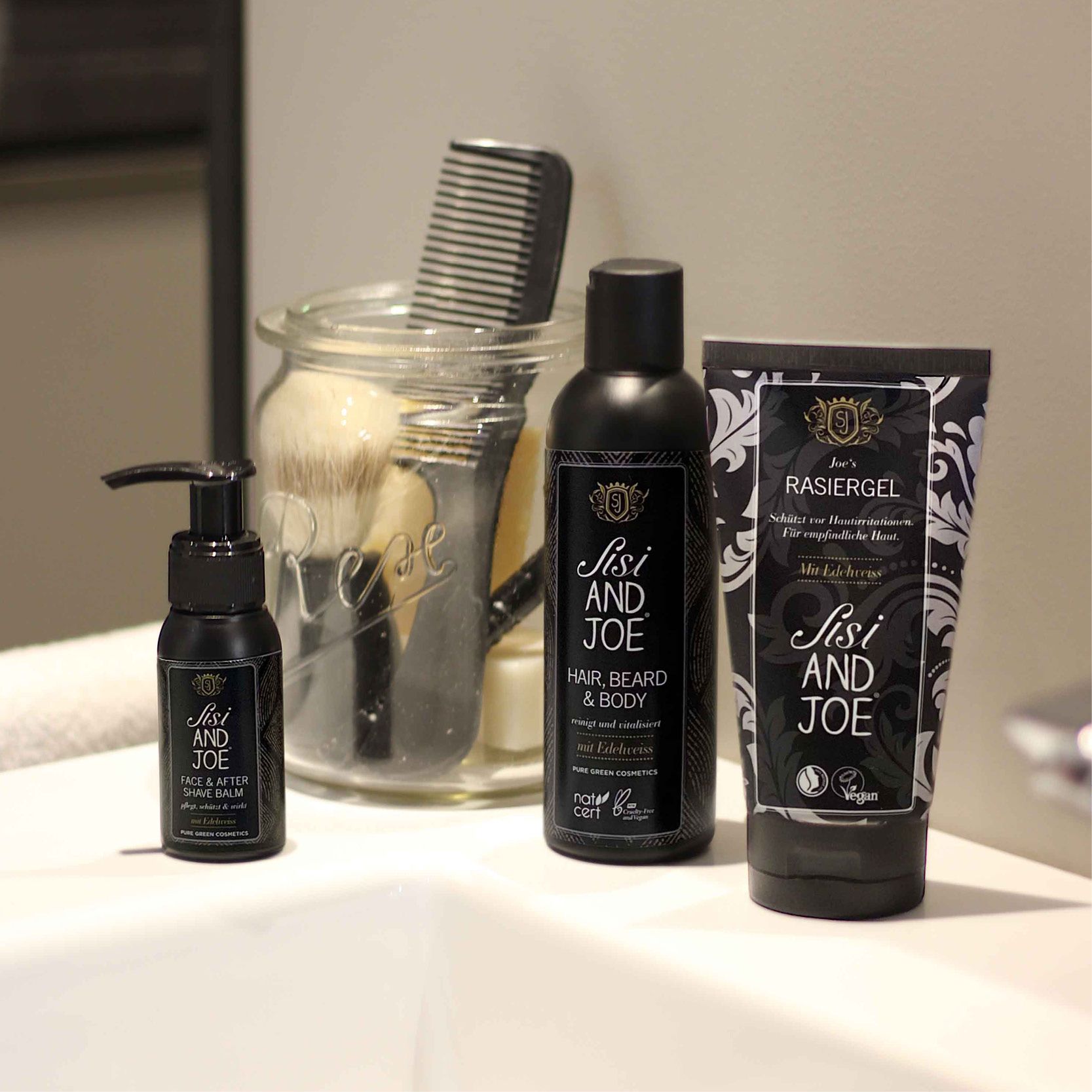 Schwarze Flasche mit Pumpe. Etikett mit Text: Face & After Shave Balm mit Edelweiß. Marke: Sisi and Joe.