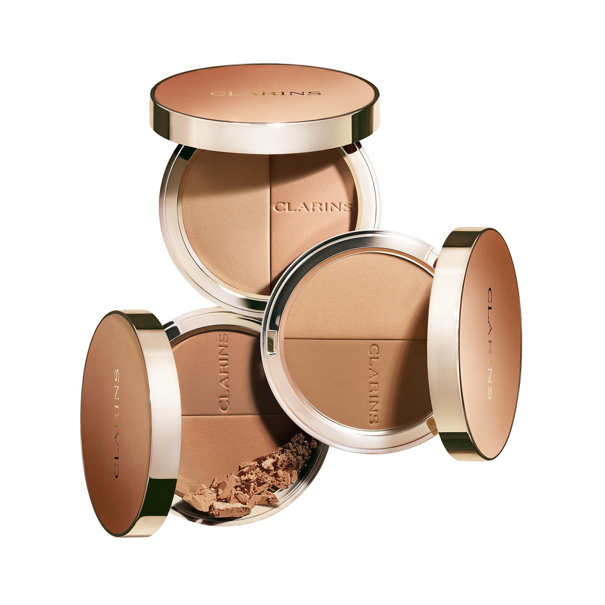 Drei Bronzer-Kompaktpuder. Zwei geöffnet, einer mit Puder. Marke Clarins. Runde Form, Braun- und Goldtöne.