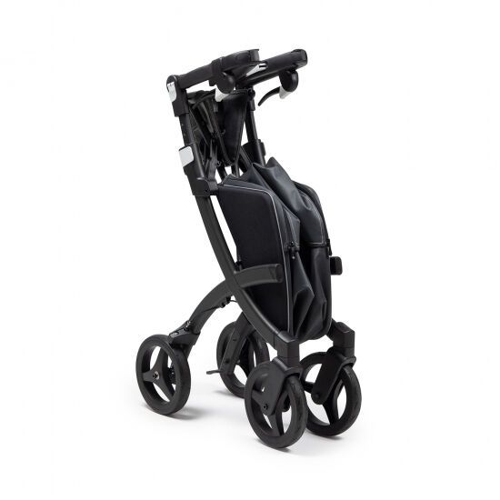 Zusammengeklappter Rollator, schwarz. Vier Räder, Handgriffe und Tasche.
