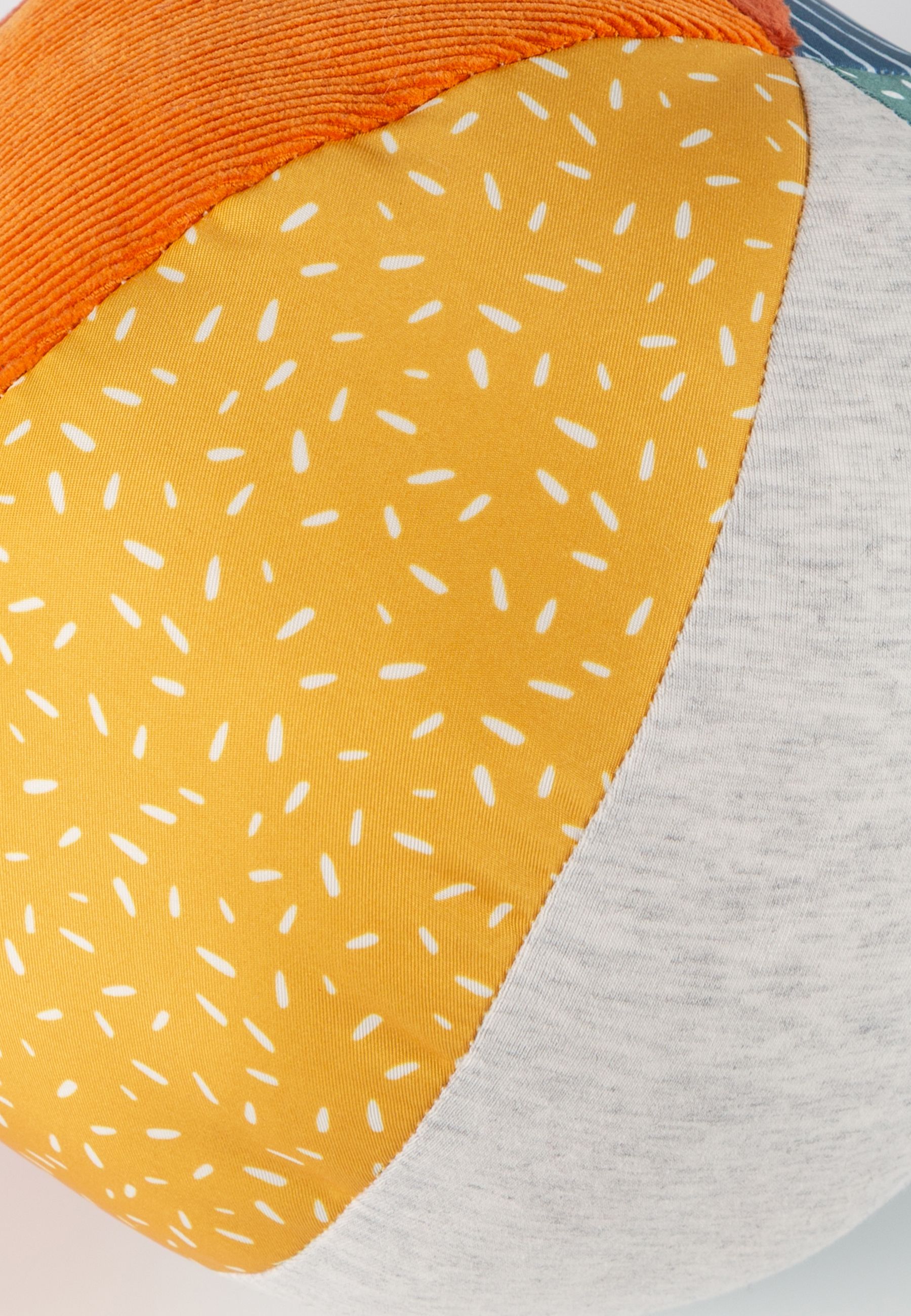 Nahaufnahme eines Softball-Segments. Gelber Stoff mit weißen Punkten und grauer Stoff.