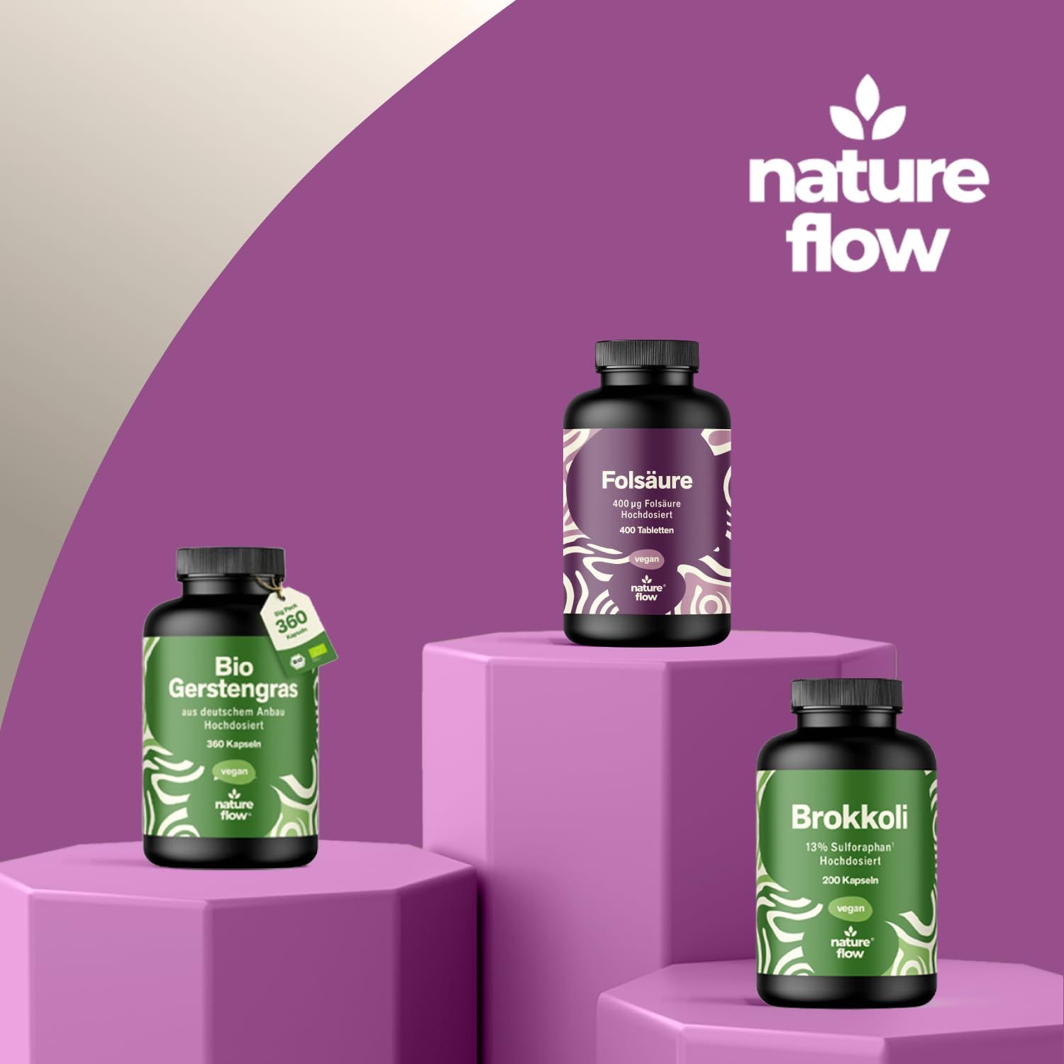 Drei Flaschen auf Podest. Folsäure-Tabletten, Bio Gerstengras, Brokkoli. Marke: nature flow. Alle Flaschen haben schwarze Deckel und Etiketten.