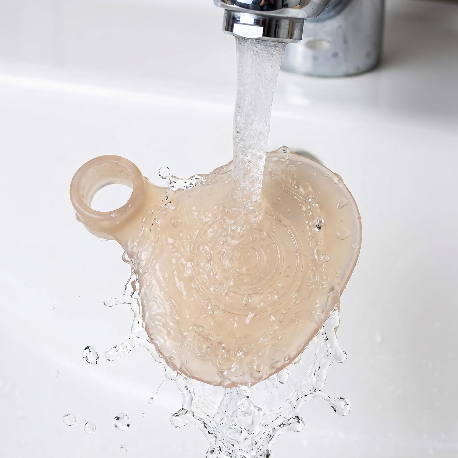 Ein einzelner Zehenschützer wird unter fließendem Wasser in einem Waschbecken gereinigt.