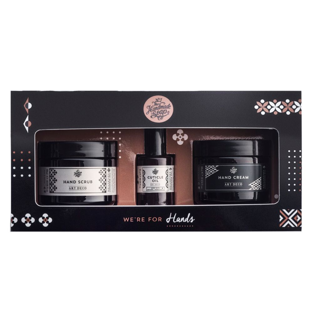 Geschenkset mit drei Produkten für die Handpflege. Schwarze Tiegel und Flasche in einer schwarzen Box. Aufschrift: Hand Scrub, Cuticle Oil, Hand Cream.