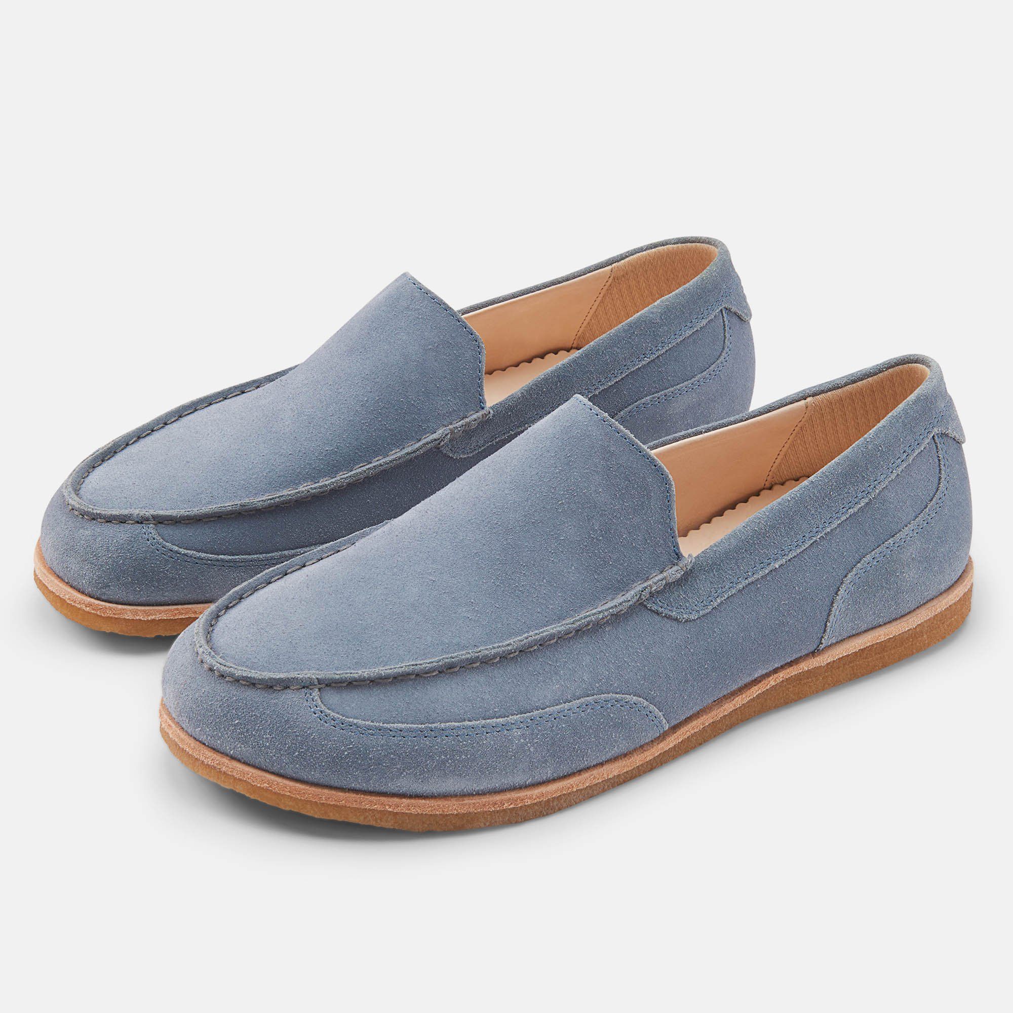 Zwei blaue Slipper mit breiter Passform. Hellbraune Sohle und Innenfutter. Obermaterial aus Wildleder.