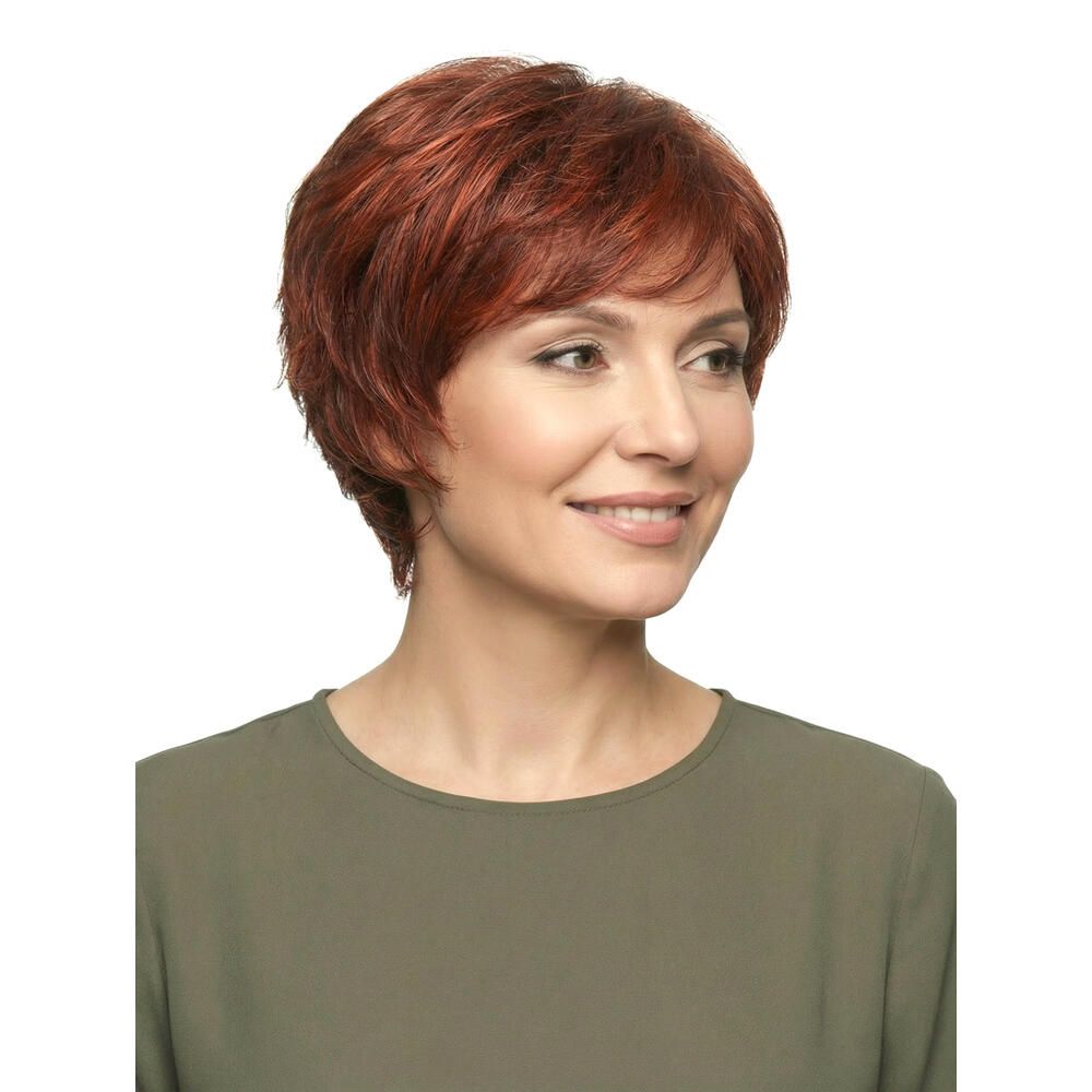 Frau mit roter Perücke. Kurzer, gewellter Haarschnitt. Dreiviertelansicht, lächelnd.