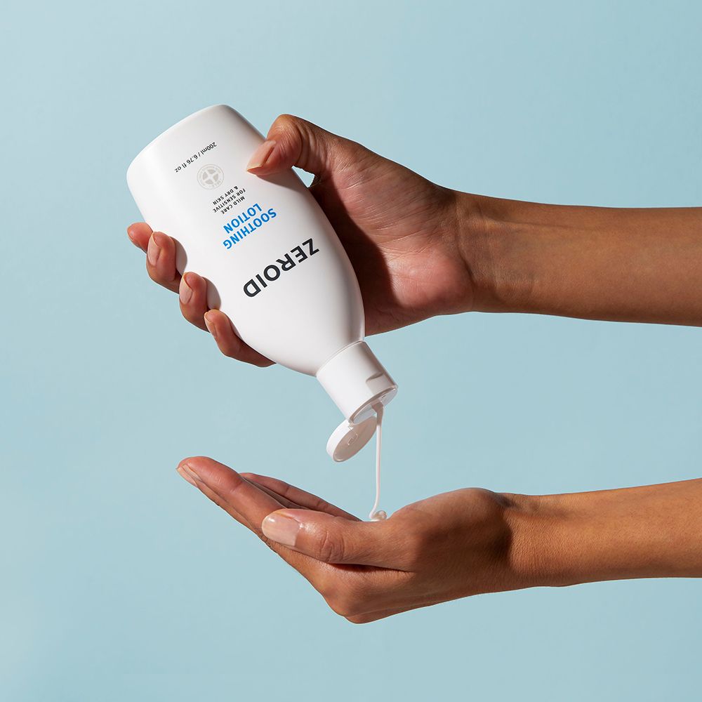 Weiße Flasche mit Klappverschluss, Produkt wird in die Hand gegossen. Aufschrift: ZEROID, Soothing Lotion. Blauer Hintergrund.
