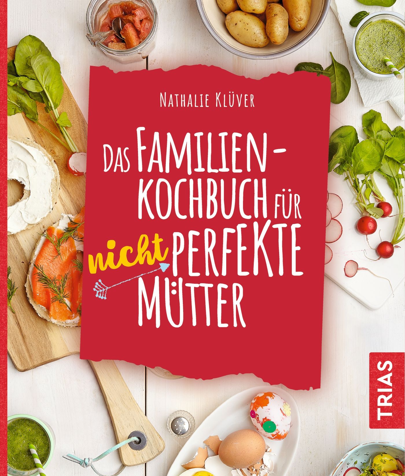 Kochbuch mit rotem Cover. Titel: Das Familienkochbuch für nicht perfekte Mütter. Autor: Nathalie Klüver. Verlag: TRIAS. Auf Tisch mit Essen.