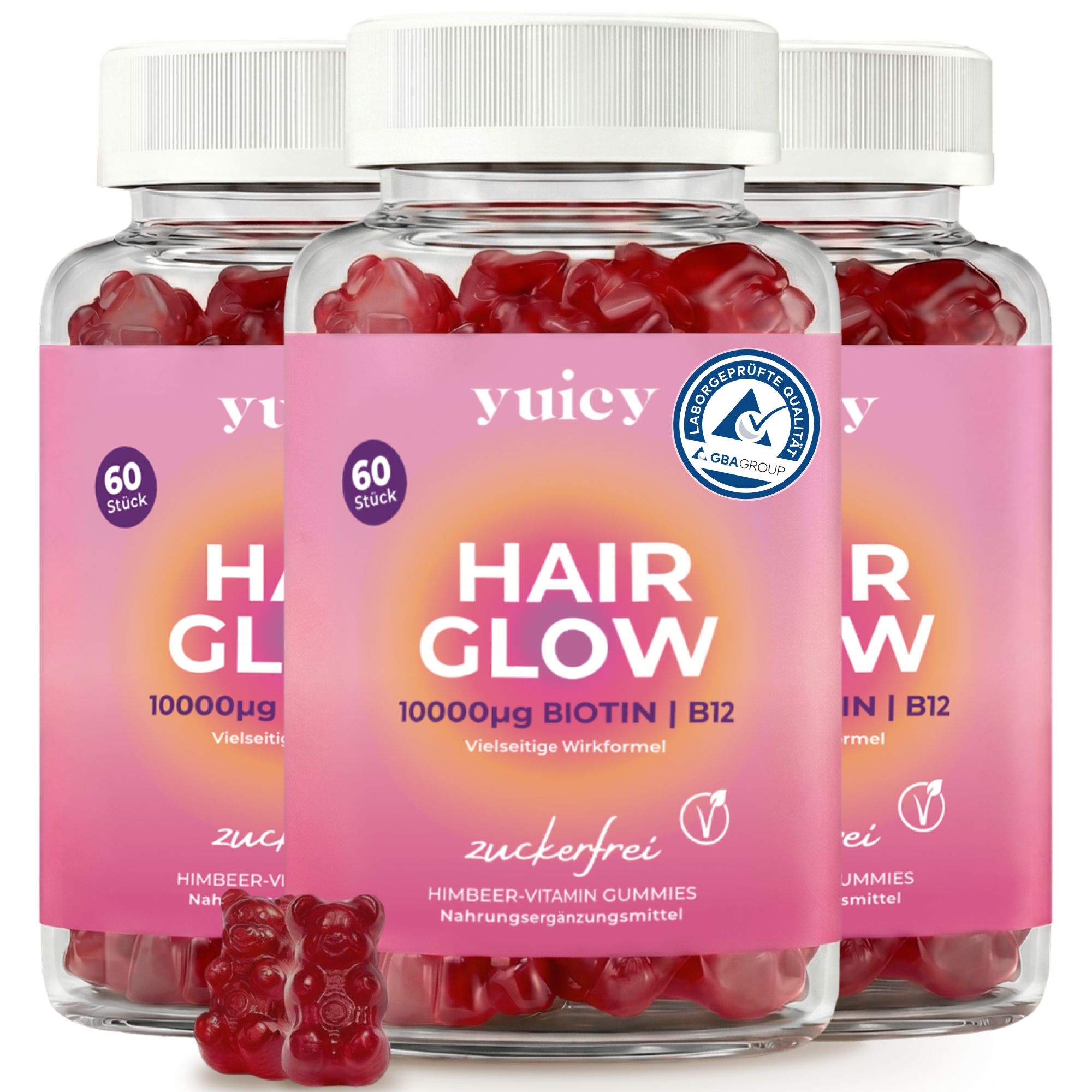 Drei Flaschen yuicy® Hair Glow Biotin. Aufschrift: Hair Glow, 10000µg Biotin | B12, zuckerfrei. Zwei rote Gummibärchen.