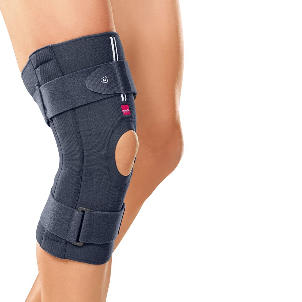 Knieorthese, dunkelgrau, mit Knieaussparung und Klettverschlüssen. Das Produkt ist am Bein einer Person angebracht.