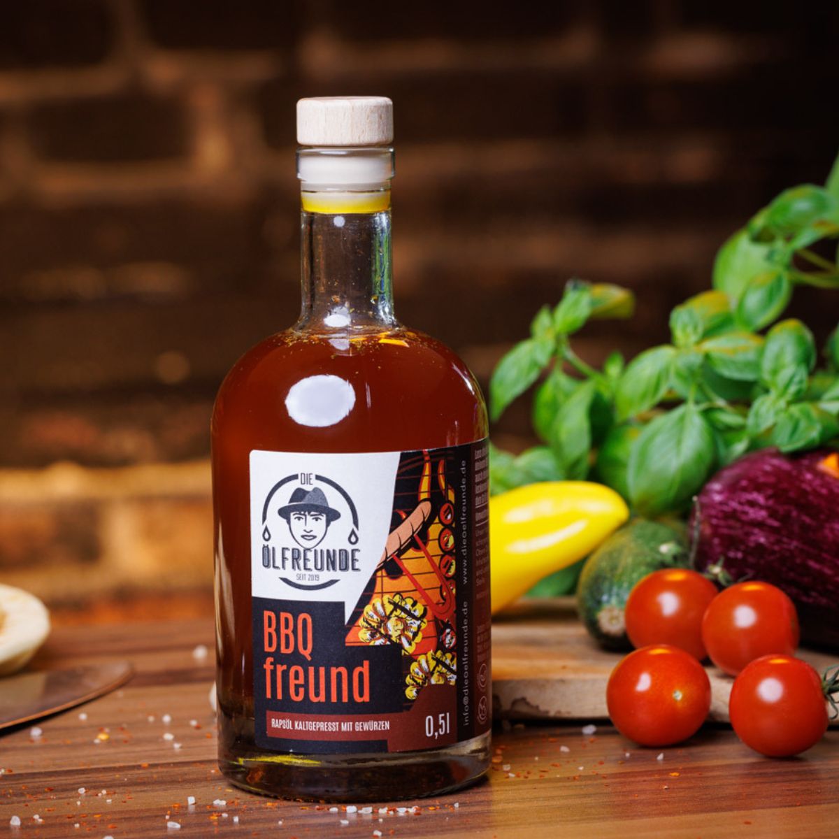 Glasflasche mit brauner Flüssigkeit und Holzverschluss. Etikett mit Logo und Schriftzug "BBQ freund". Gemüse im Hintergrund.