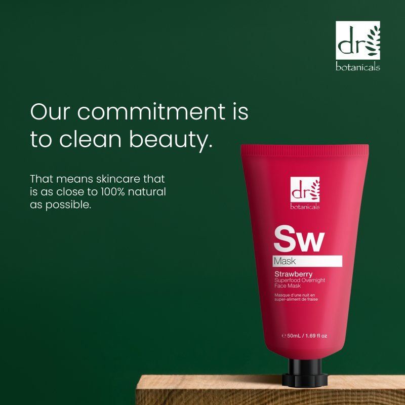 Rote Tube Dr. Botanicals Erdbeer-Gesichtsmaske neben Holzblock, mit Text über saubere Schönheit und natürliche Inhaltsstoffe.