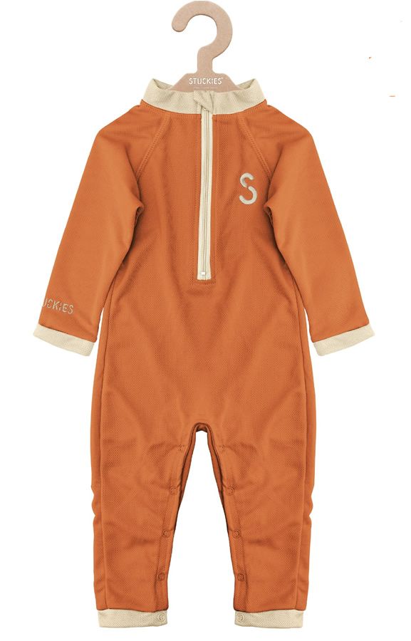 UV-Schutzanzug, orangefarben, mit Reißverschluss und "S"-Logo. Marke "Stuckies" am Ärmel. Hängt an einem Kleiderbügel.