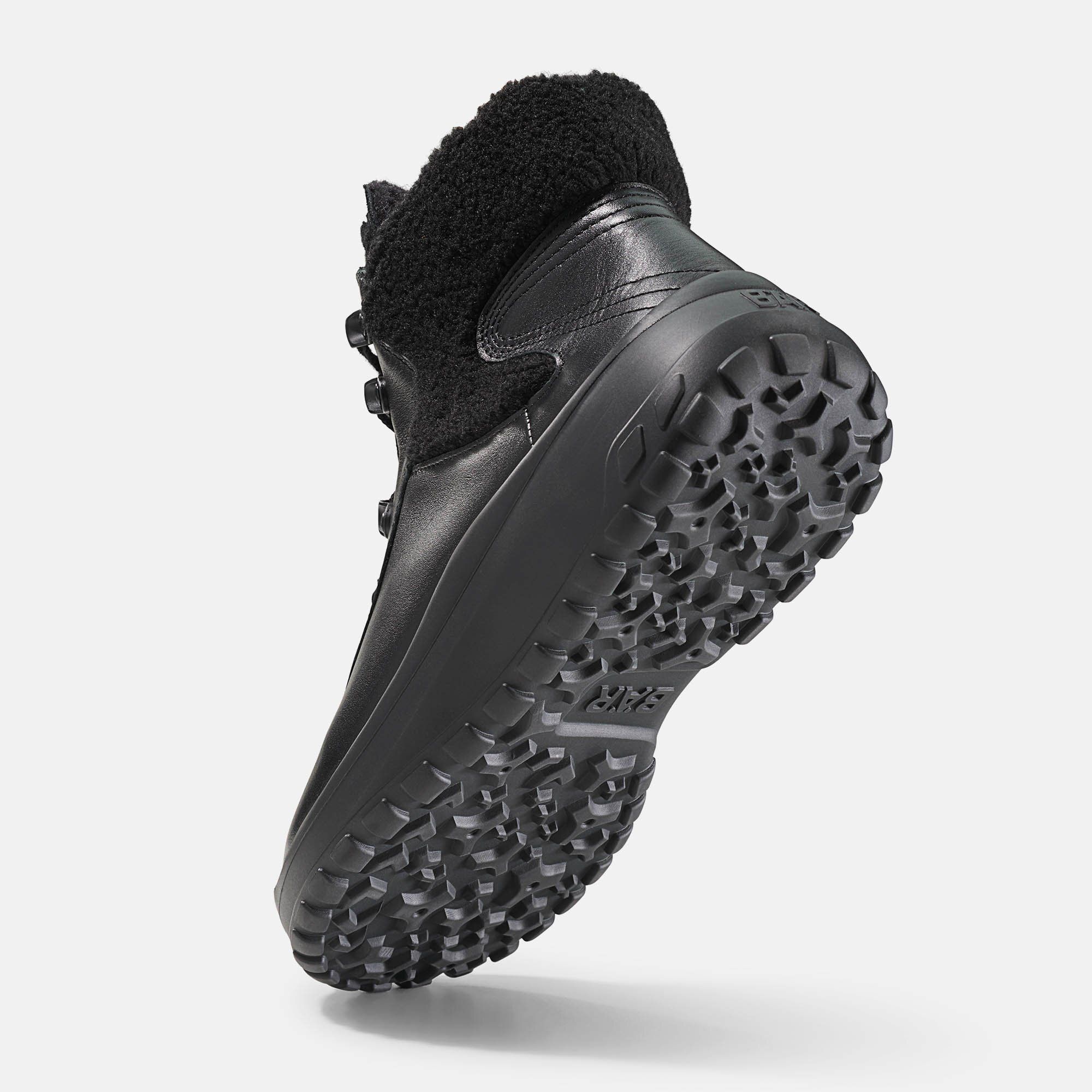 Schwarze Stiefelette mit Schnürung und Fellbesatz. Breiter Schaft, dicke Sohle. Schuh von unten.