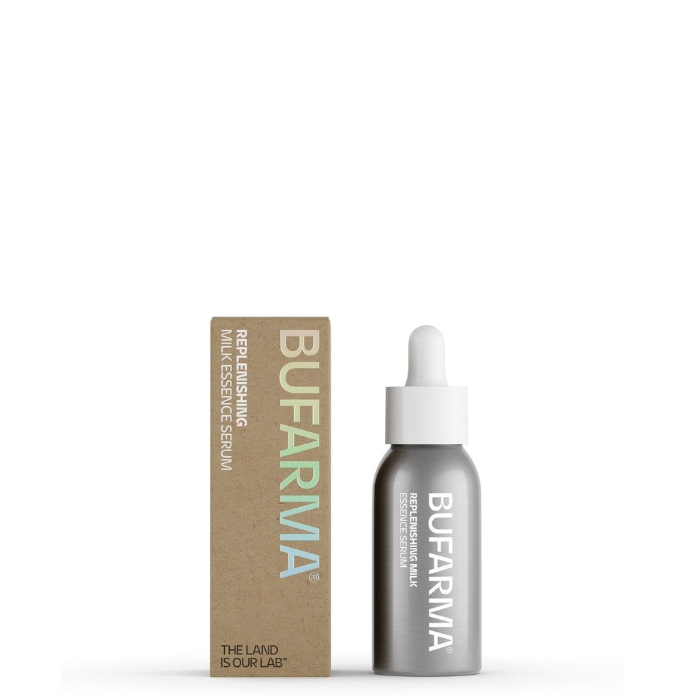 Una bottiglia grigia e una scatola marrone di Bufarma Siero Naturale e Biologico. La bottiglia ha un contagocce bianco e il prodotto si chiama "Replenishing Milk Essence Serum". La scatola riporta anche il nome del marchio e del prodotto.