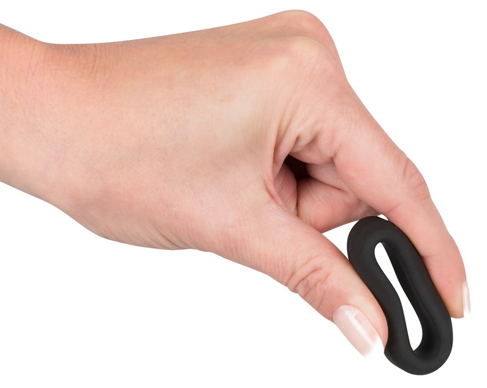 Schwarzer Penisring in einer Hand gehalten. Ring ist flexibel.
