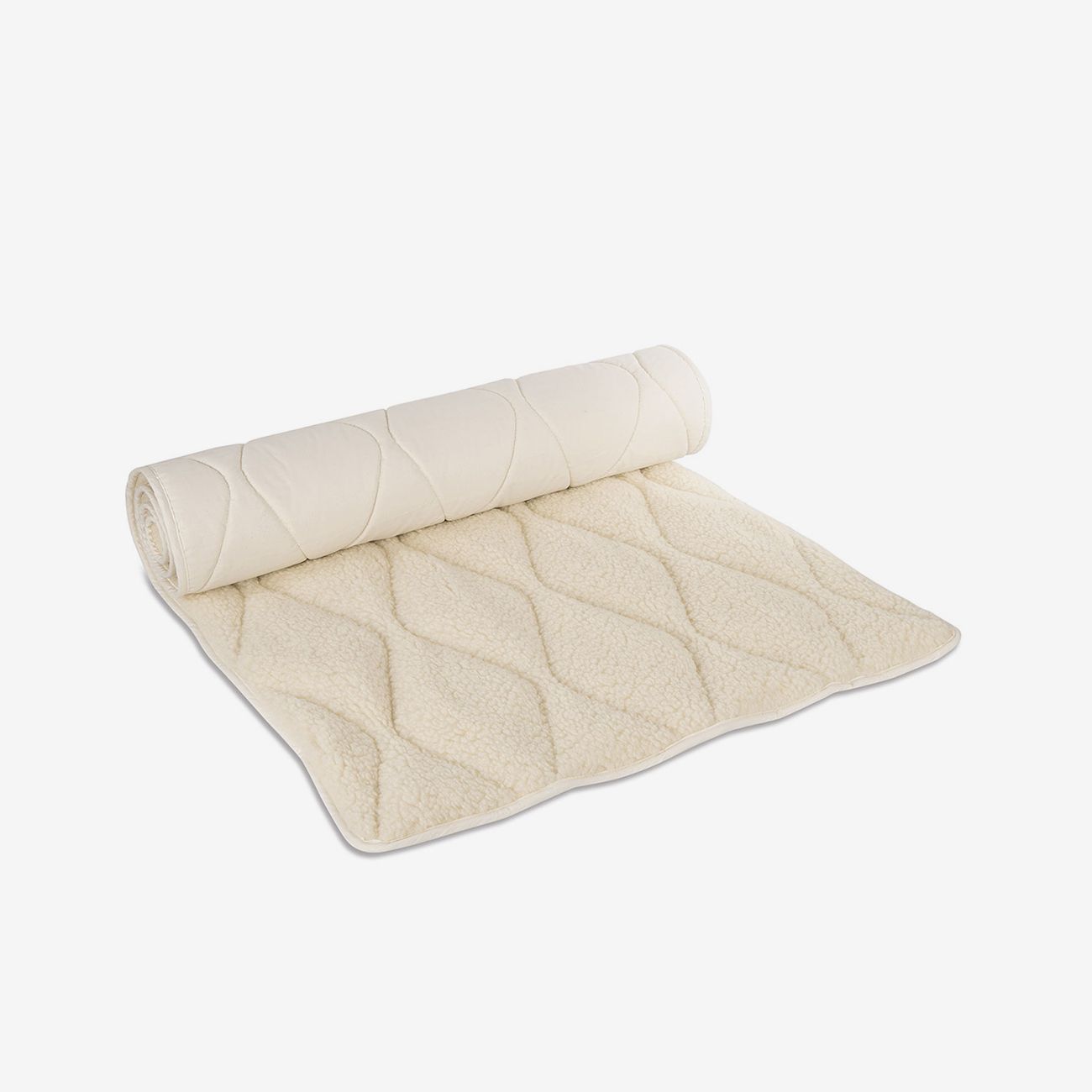 Beige Yogamatte aus Schurwolle, teilweise gerollt. Mit wellenförmigem Steppmuster und weißem Rand.