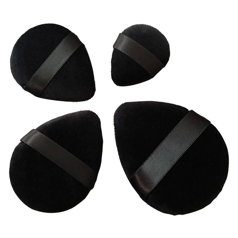 Vier schwarze Puderquasten mit Bändern. Zwei tropfenförmig, zwei rundlich.