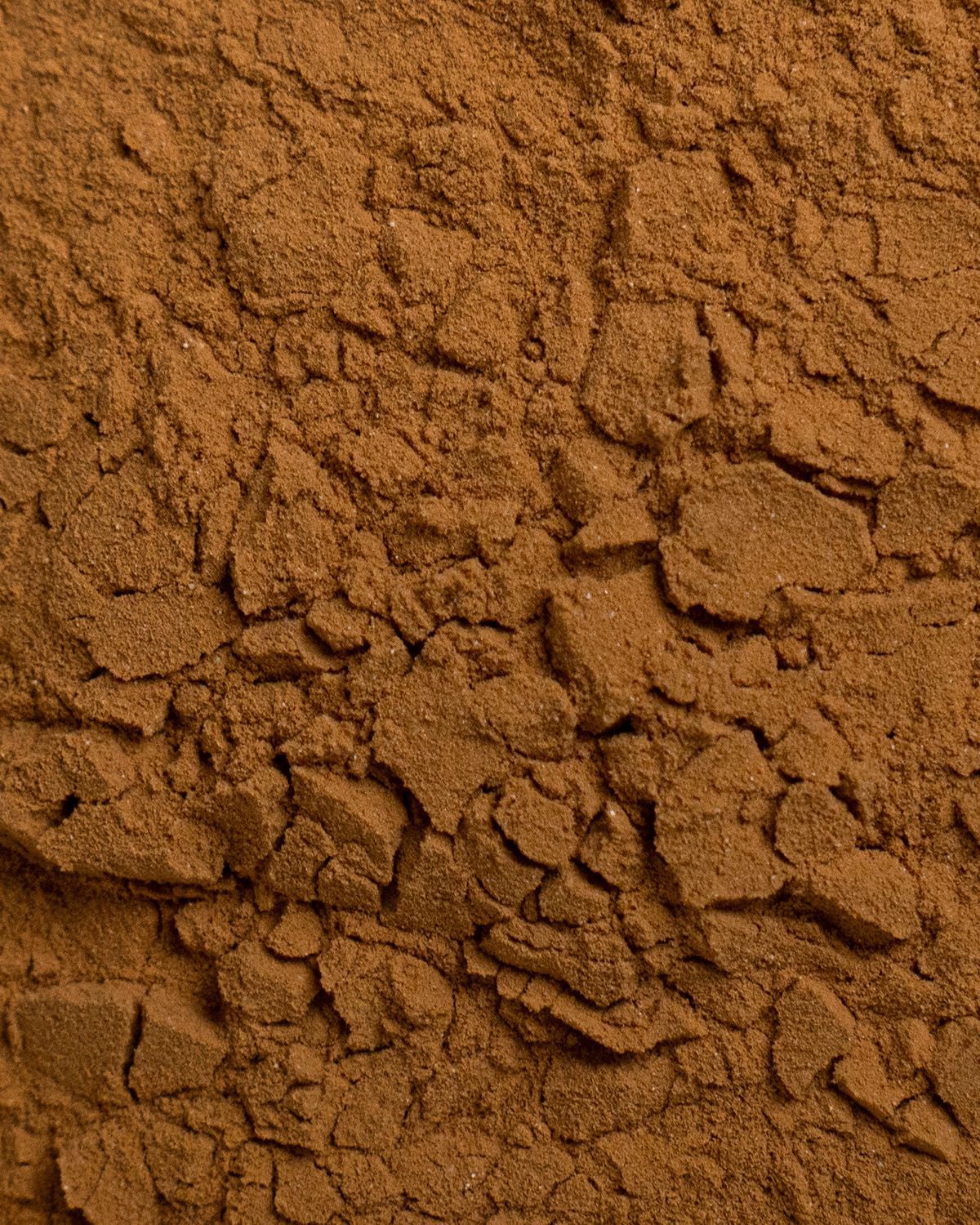Nahaufnahme von braunem Pulver mit grober Textur. Einzelne Partikel sind sichtbar.
