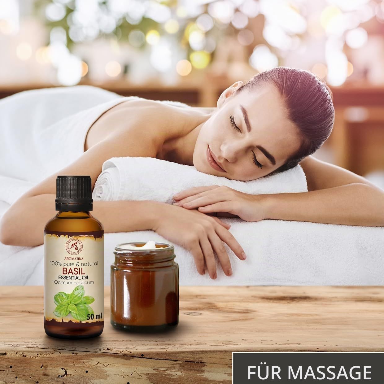 Frau entspannt bei einer Massage, daneben eine Flasche Basilikumöl und ein Glas.