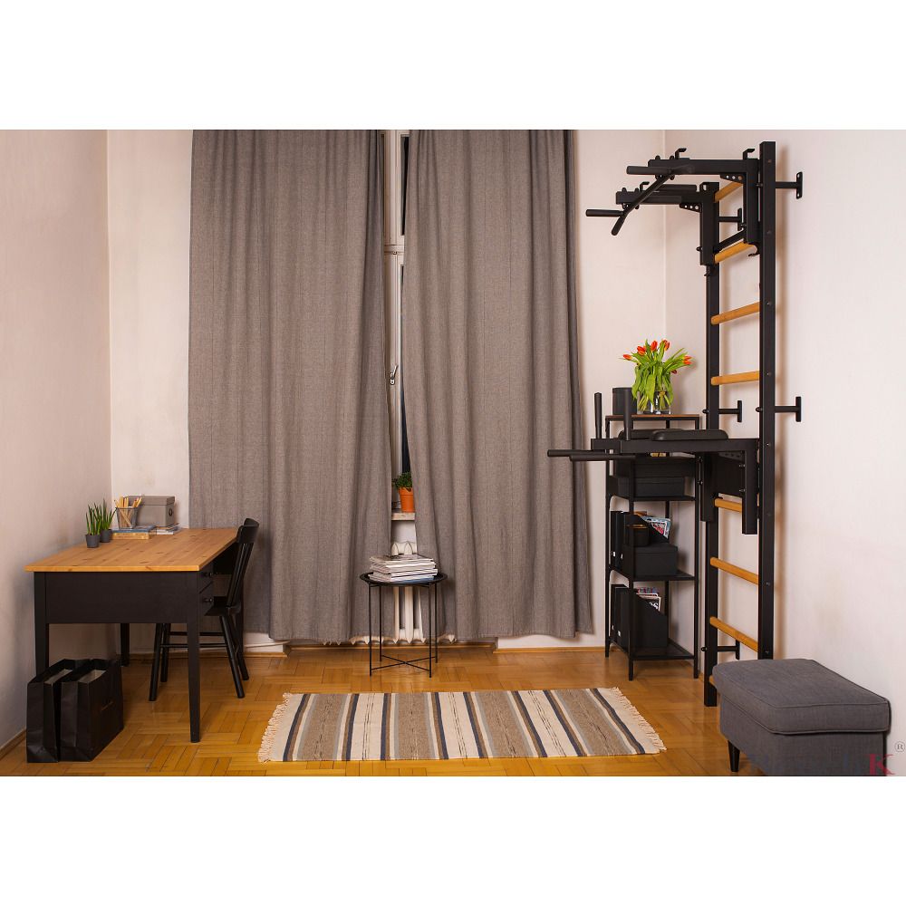 Sprossenwand Fitness-System 732, schwarz mit Holzsprossen, an Wand montiert. Zimmer mit Tisch, Stuhl, Vorhängen und Teppich.