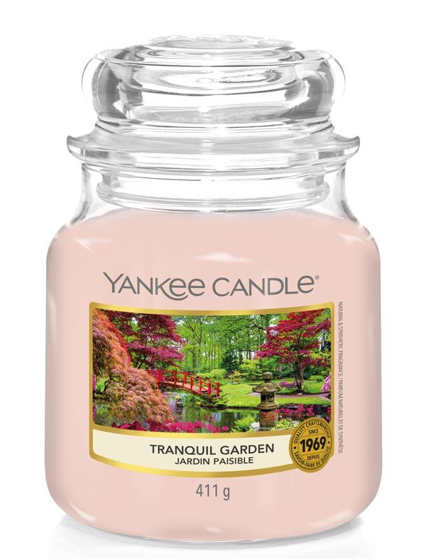 Duftkerze im Glas mit Deckel. Etikett mit Landschaftsmotiv und Aufschrift "Tranquil Garden". Marke: Yankee Candle. Gewicht: 411g.