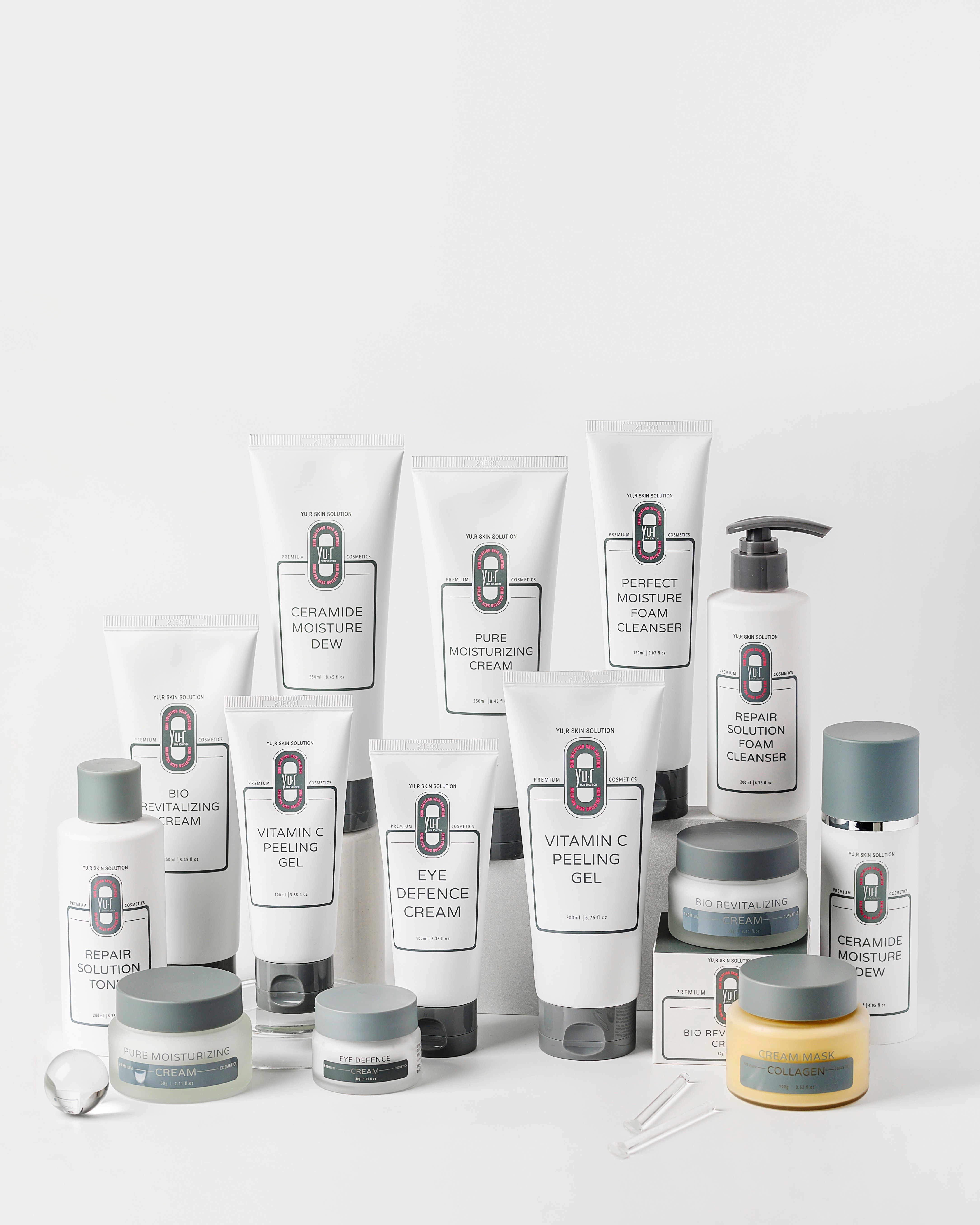 Verschiedene Kosmetikprodukte, darunter Tuben mit Vitamin C Peeling Gel. Aufschrift: YOUR SKIN SOLUTION.